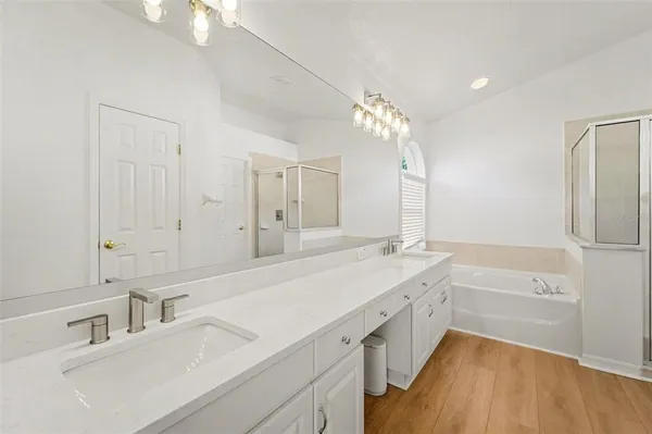 a spacious bathroom with a tub sink and mirror