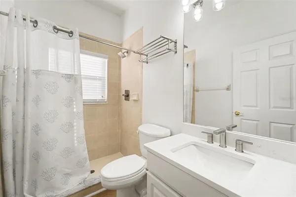a bathroom with a sink toilet vanity and shower