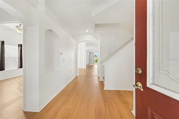 a view of a hallway with wooden floor and staircase