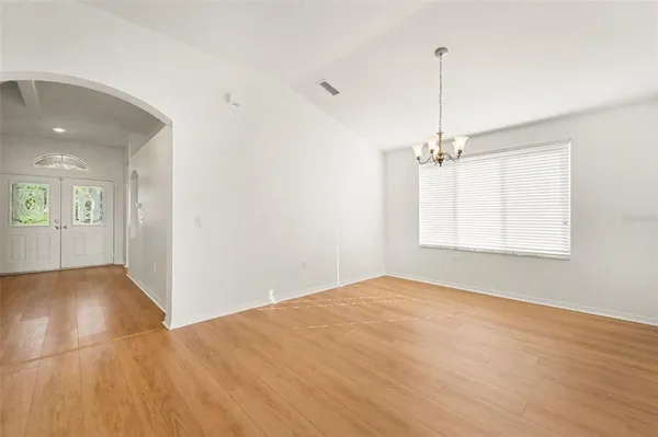 a view of an empty room with window and wooden floor