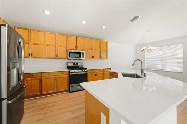 a kitchen with stainless steel appliances granite countertop a sink a stove and a refrigerator