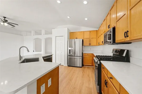 a kitchen with a sink a stove a refrigerator cabinets and a counter top space