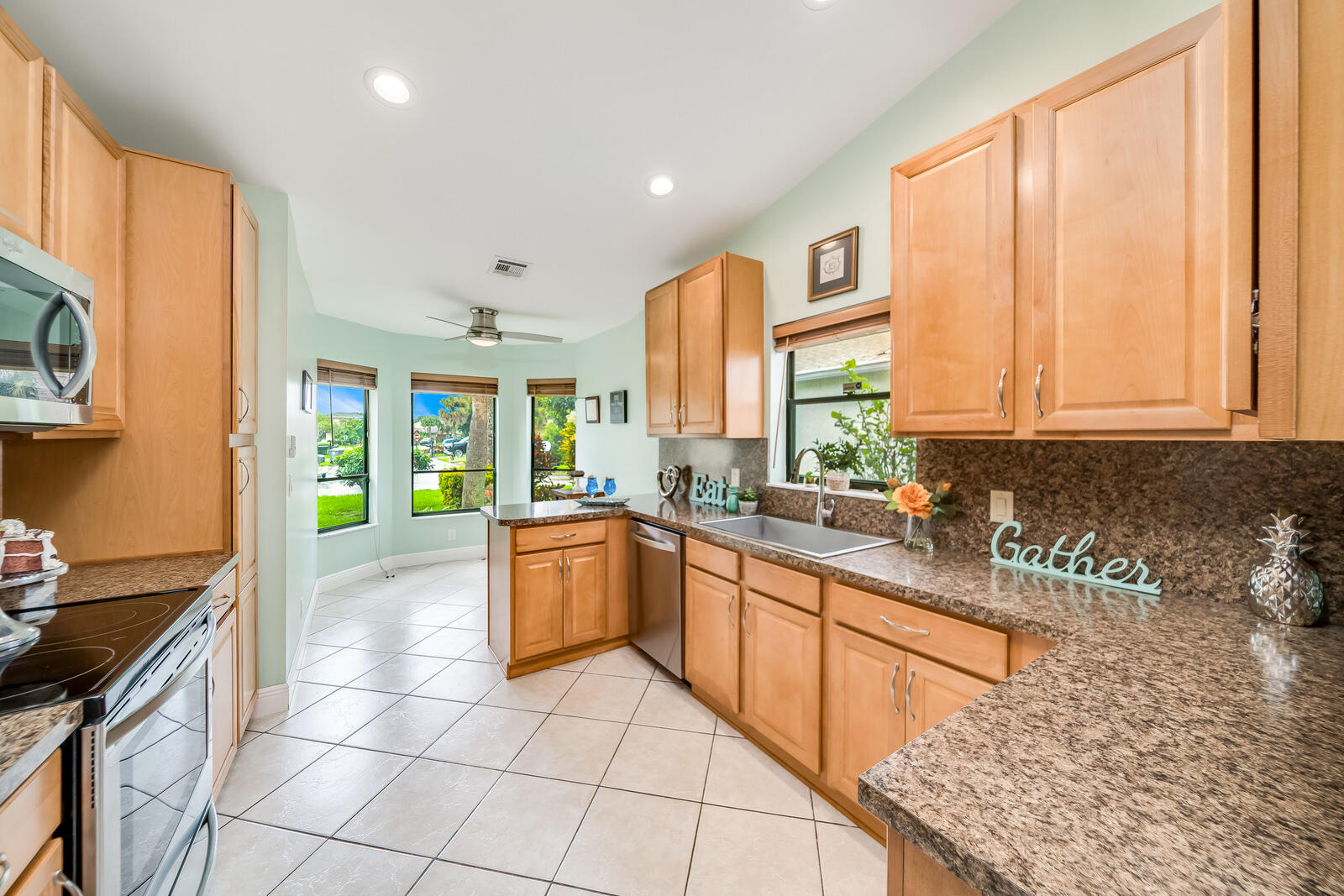 23250 Sedawie Drive Boca Raton, FL 33433 - Photo 18 of 42 a large kitchen with stainless steel appliances granite countertop a stove a sink and a microwave
