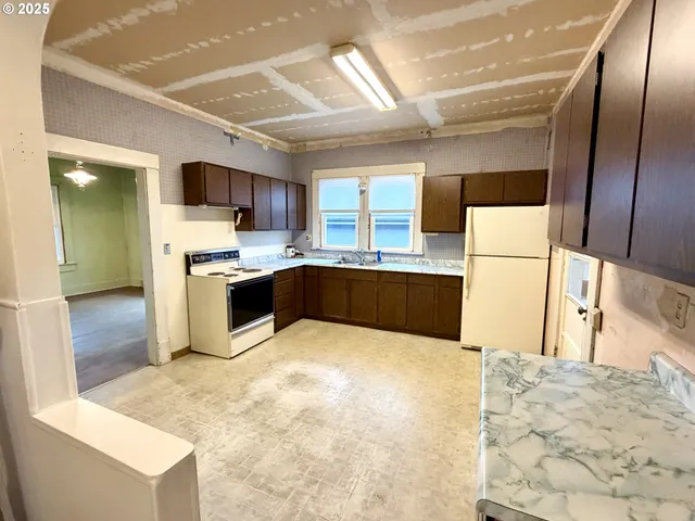 a large kitchen with kitchen island granite countertop a sink stainless steel appliances and cabinets