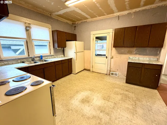 a kitchen with granite countertop a sink stove and refrigerator
