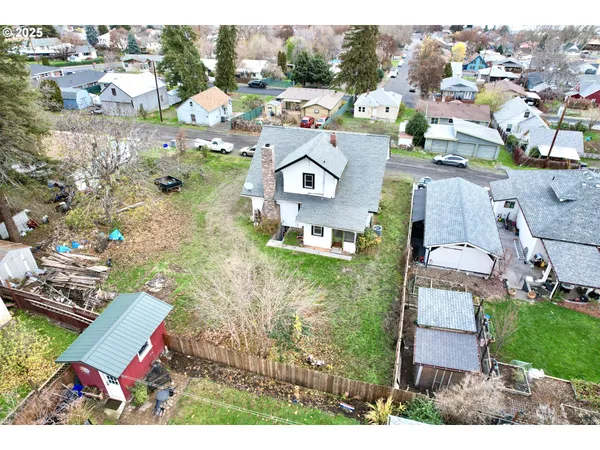 an aerial view of residential houses with outdoor space and parking