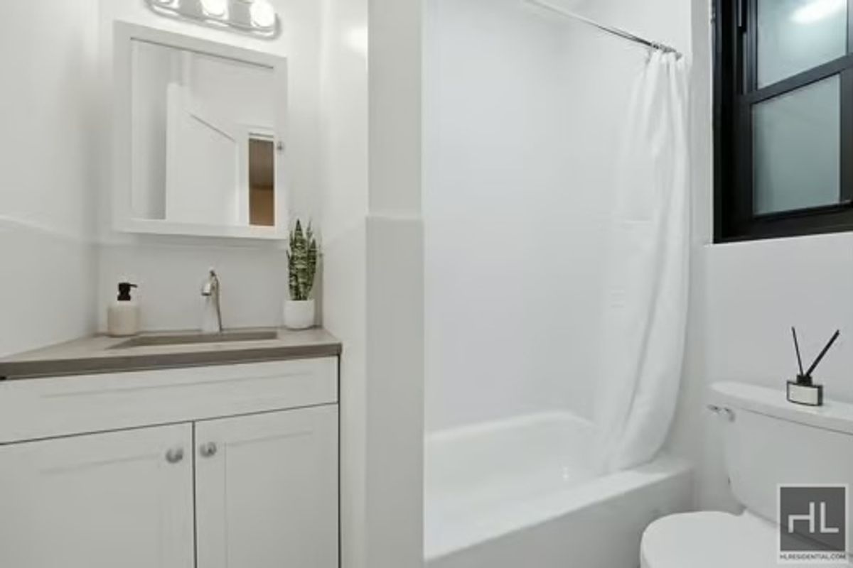 160 East 3rd Street, Unit 2F Manhattan, NY 10009 - Photo 17 of 20 a bathroom with a granite countertop sink toilet and shower