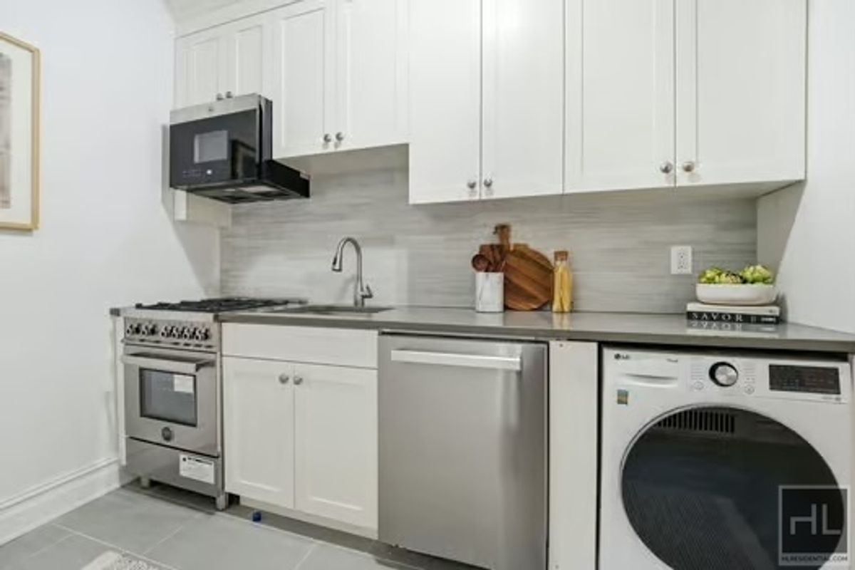 160 East 3rd Street, Unit 2F Manhattan, NY 10009 - Photo 9 of 20 a kitchen with stainless steel appliances granite countertop a sink and a stove