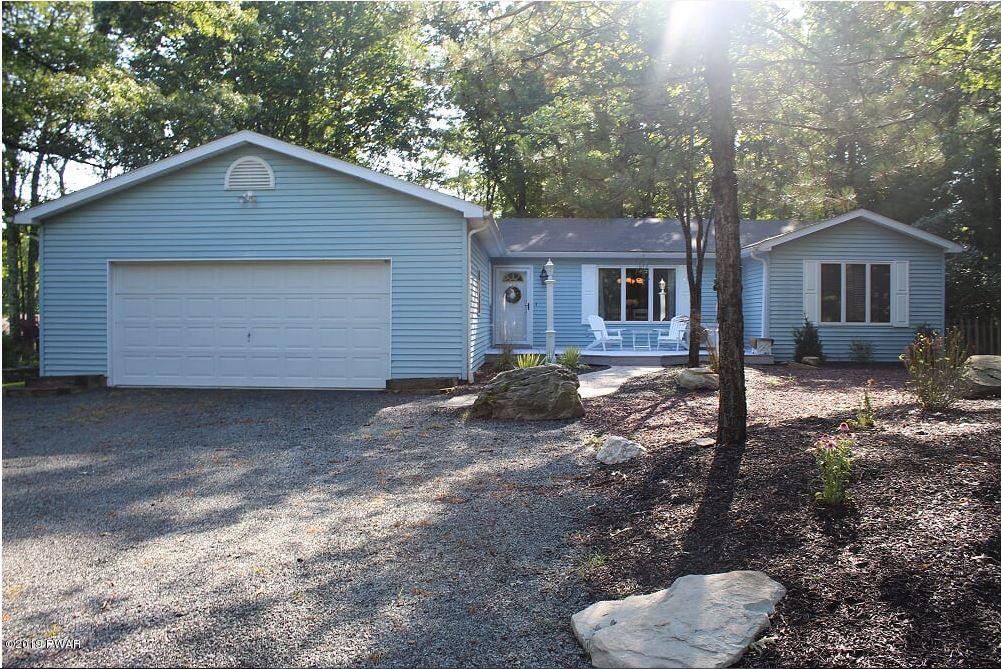 105 Rodeo Drive Hawley, PA 18428 - Photo 1 of 42 a front view of a house with a yard and garage
