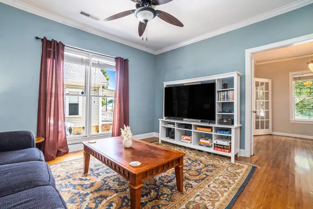 a living room with furniture flat screen tv and wooden floor