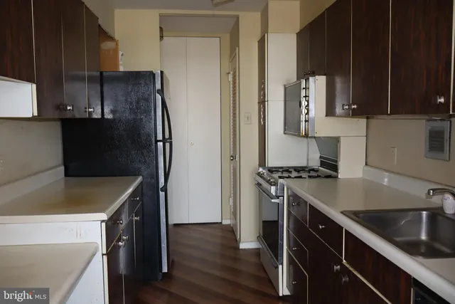 a kitchen with stainless steel appliances granite countertop a sink refrigerator stove and microwave