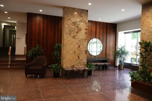 a living room with furniture a mirror and a clock