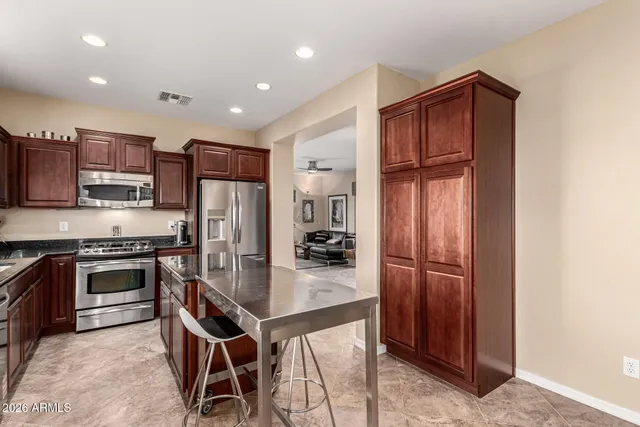 a kitchen with kitchen island granite countertop wooden cabinets and stainless steel appliances