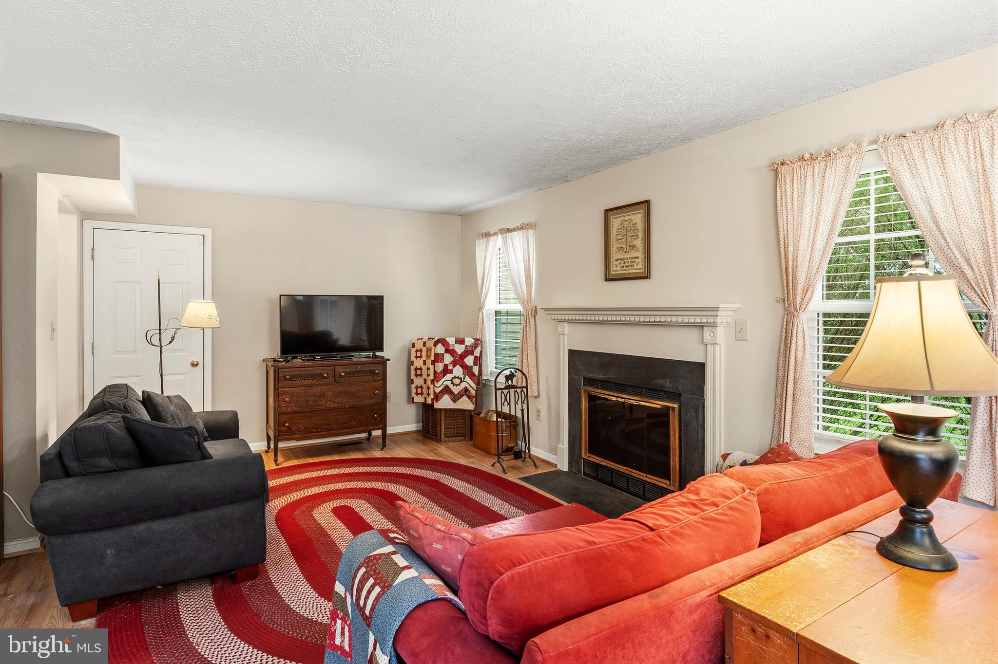 6415 Michael Elizabeth Way Hanover, MD 21076 - Photo 13 of 32 a living room with furniture a flat screen tv and a fireplace