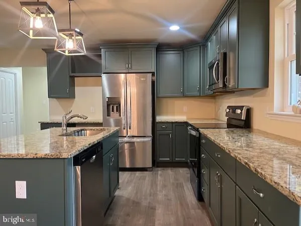a kitchen with stainless steel appliances granite countertop cabinets a refrigerator and a sink