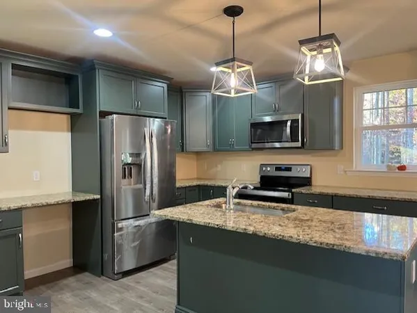 a kitchen with granite countertop a refrigerator and a sink