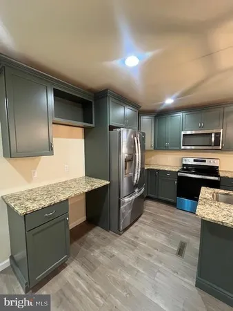 a kitchen with stainless steel appliances granite countertop a sink a stove and a refrigerator