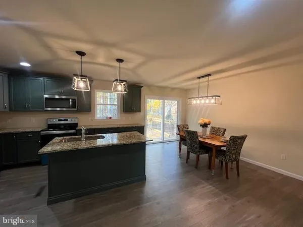 a spacious bedroom with a bed and wooden floor