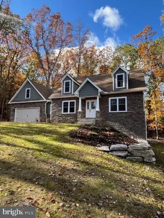 a view of a house with a big yard and large trees