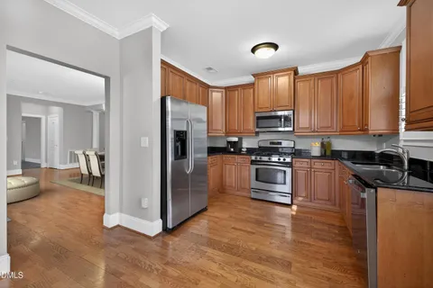 a kitchen with stainless steel appliances granite countertop a stove a sink and a refrigerator