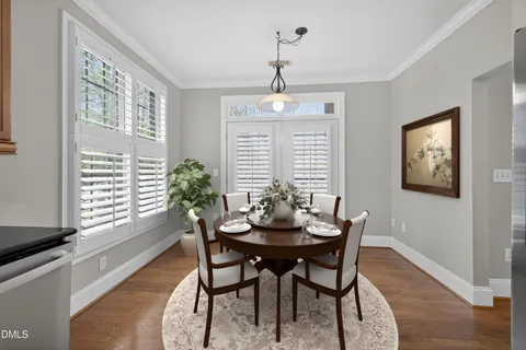 a dining room with furniture a chandelier and wooden floor