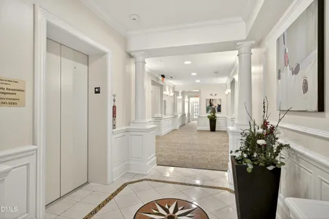 a view of a hallway with dining table and chairs