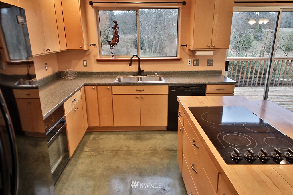 6301 Wahl Road Freeland, WA 98249 - Photo 11 of 40 a kitchen with stainless steel appliances granite countertop a sink stove and cabinets
