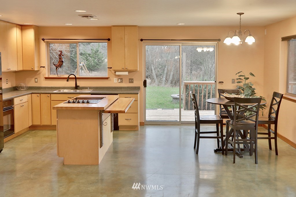 6301 Wahl Road Freeland, WA 98249 - Photo 13 of 40 a kitchen with stainless steel appliances a table and chairs in it