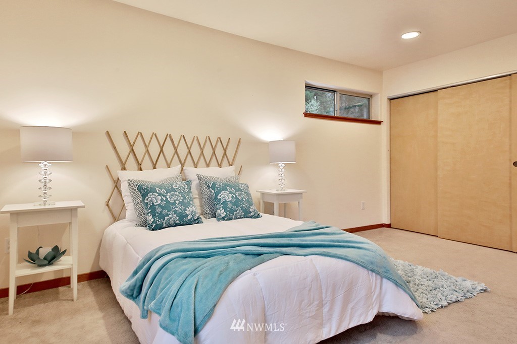 6301 Wahl Road Freeland, WA 98249 - Photo 20 of 40 a bedroom with a large bed and a lamp
