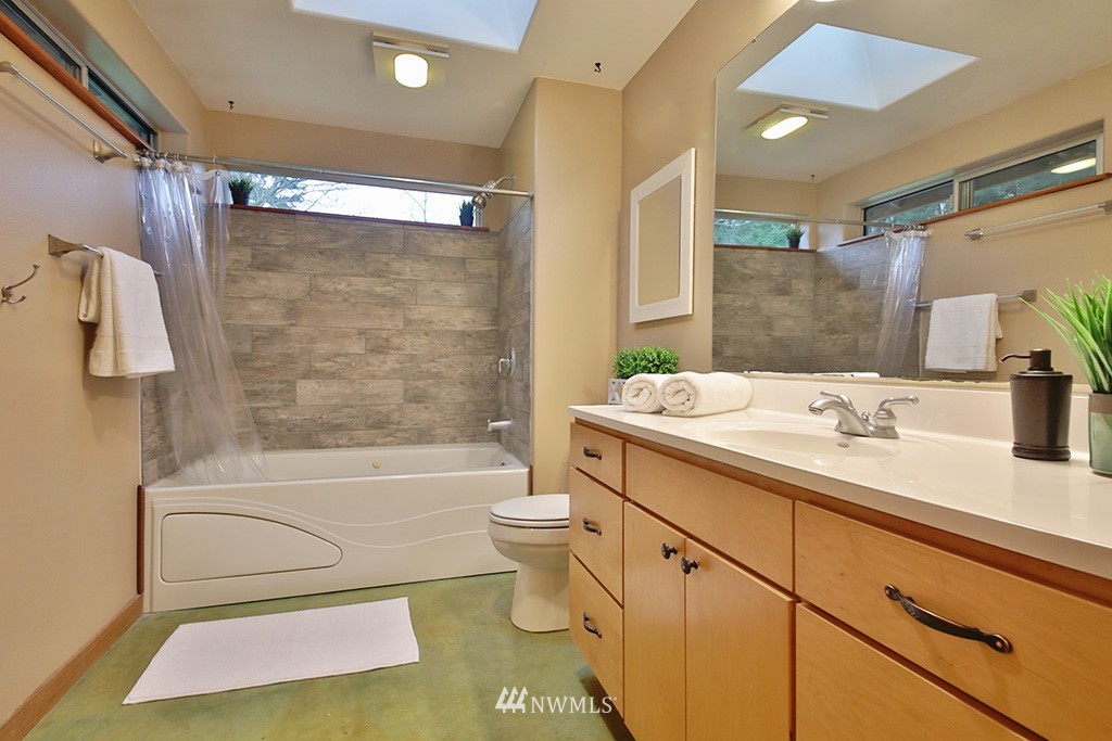 6301 Wahl Road Freeland, WA 98249 - Photo 21 of 40 a bathroom with a sink a toilet a mirror a bathtub and shower