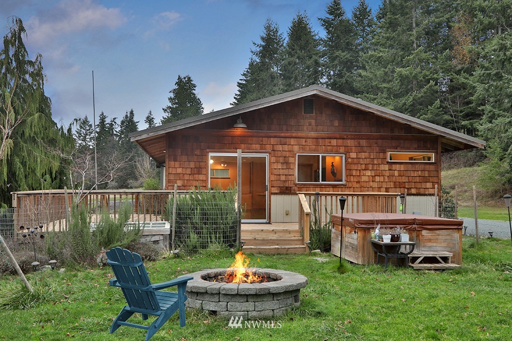 6301 Wahl Road Freeland, WA 98249 - Photo 4 of 40 a front view of a house with a yard table and chairs