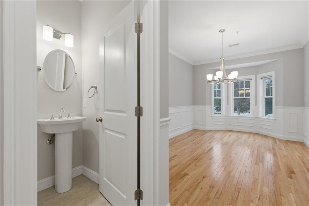 28 Eastover Road, Unit 28 Walpole, MA 02081 - Photo 11 of 34 a view of a room with wooden floor and chandelier