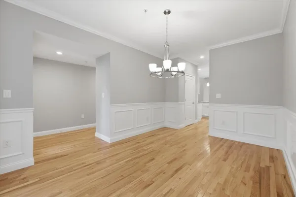 a view of a livingroom with a chandelier wooden floor and chandelier