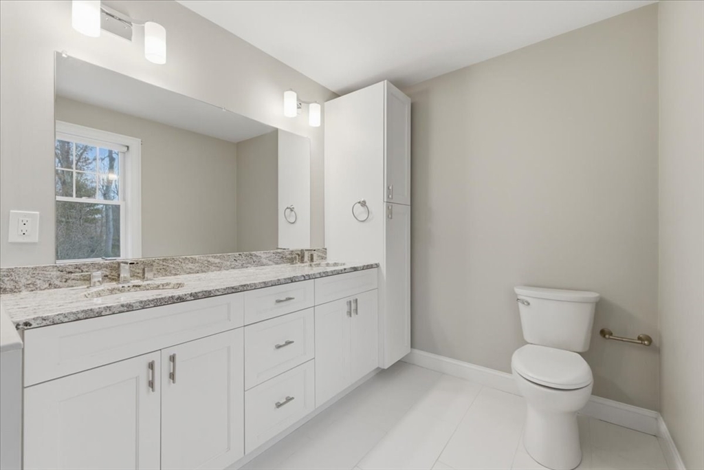 28 Eastover Road, Unit 28 Walpole, MA 02081 - Photo 20 of 34 a bathroom with a granite countertop toilet sink and mirror