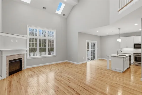 a view of an empty room with window and wooden floor