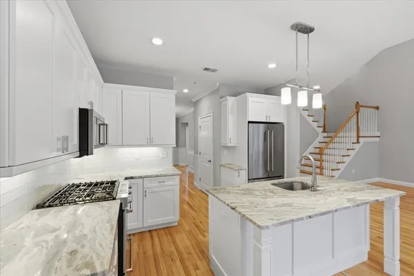 a kitchen with a sink a counter top space stainless steel appliances and cabinets
