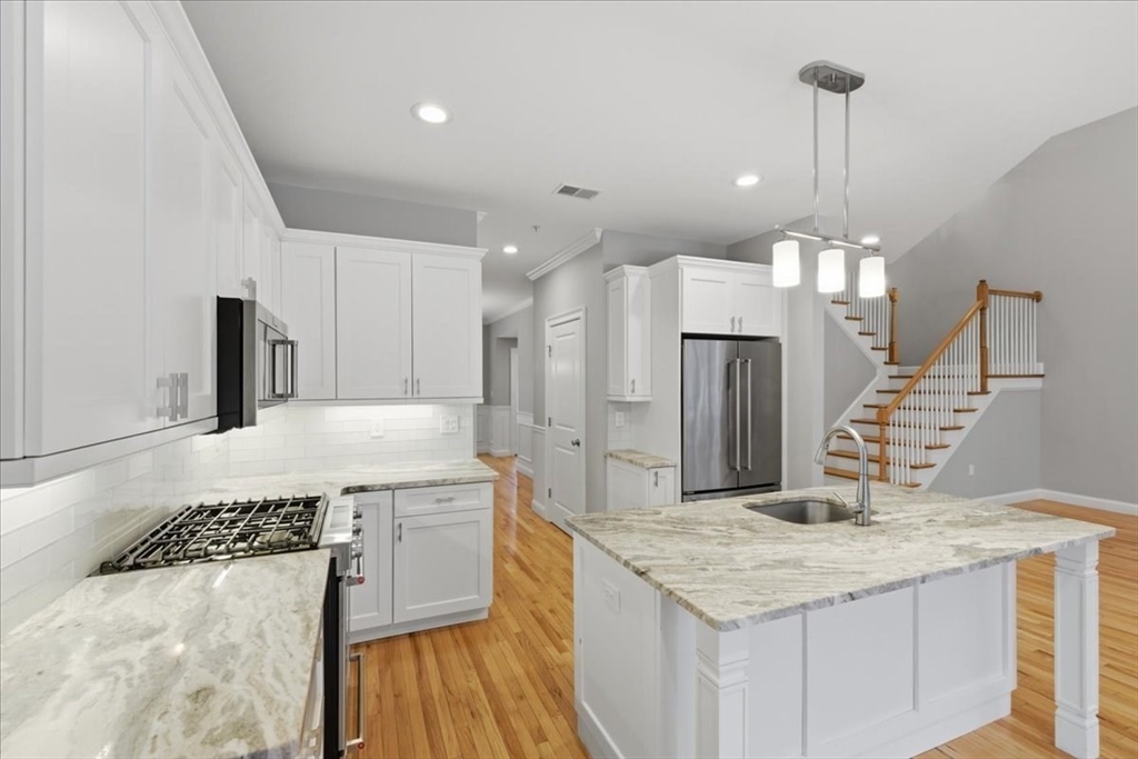 28 Eastover Road, Unit 28 Walpole, MA 02081 - Photo 6 of 34 a kitchen with a sink a counter top space stainless steel appliances and cabinets