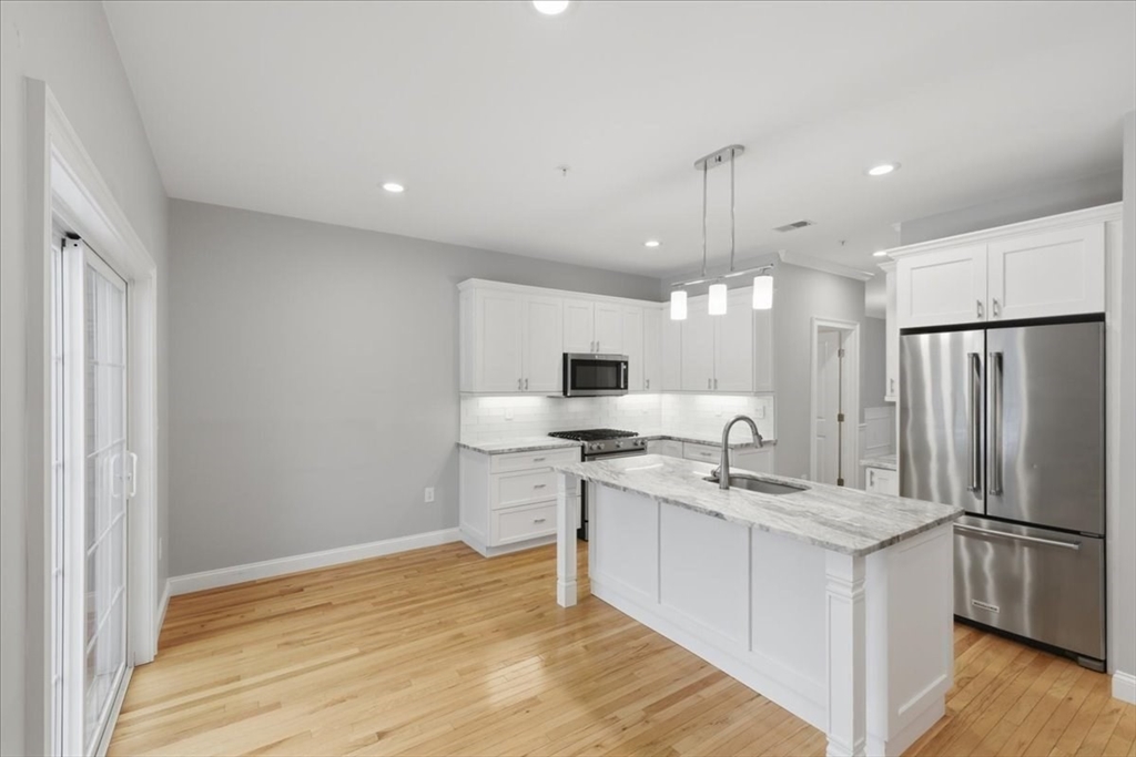28 Eastover Road, Unit 28 Walpole, MA 02081 - Photo 7 of 34 a kitchen with a sink appliances and cabinets