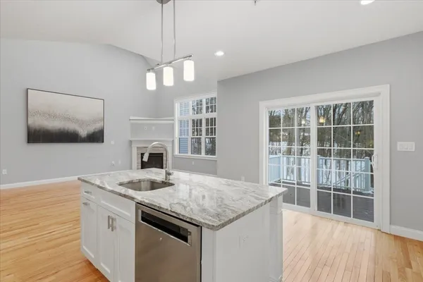 a kitchen with granite countertop a stove and a wooden floor