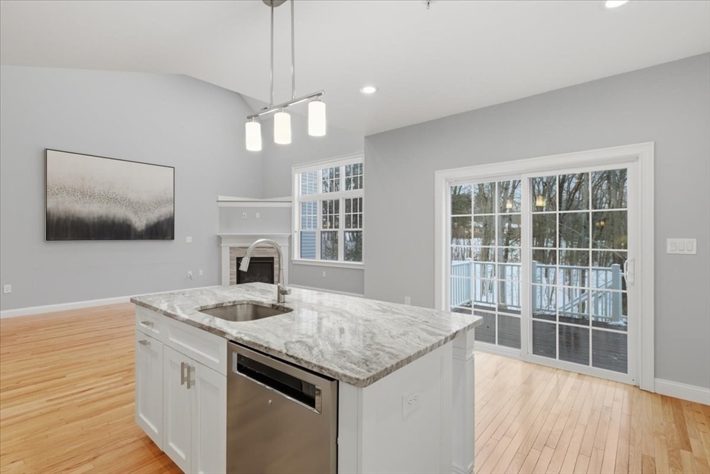 28 Eastover Road, Unit 28 Walpole, MA 02081 - Photo 8 of 34 a kitchen with granite countertop a stove and a wooden floor