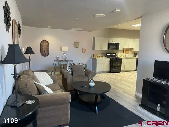 a living room with furniture a dining table and kitchen view