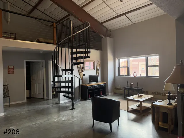 a living room with furniture gym equipment and a book shelf