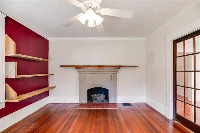 a view of a livingroom with wooden floor and a fireplace