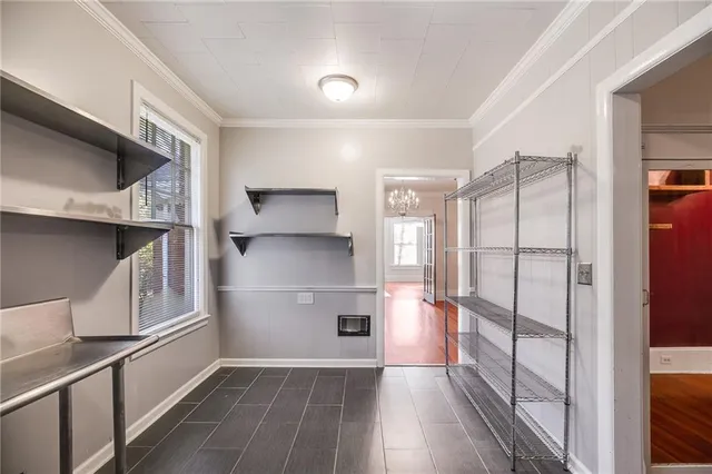 a view of a refrigerator in kitchen and an empty room