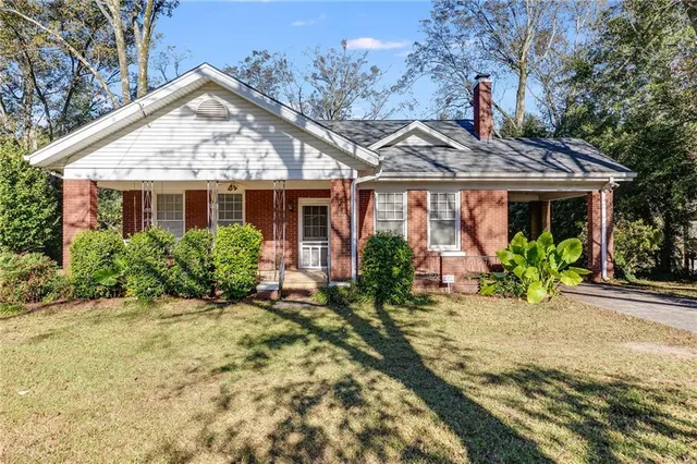 a front view of house with yard and trees around