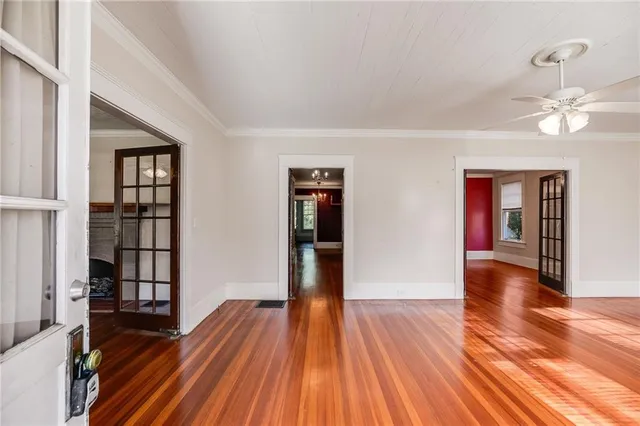 a view of empty room with wooden floor and fan