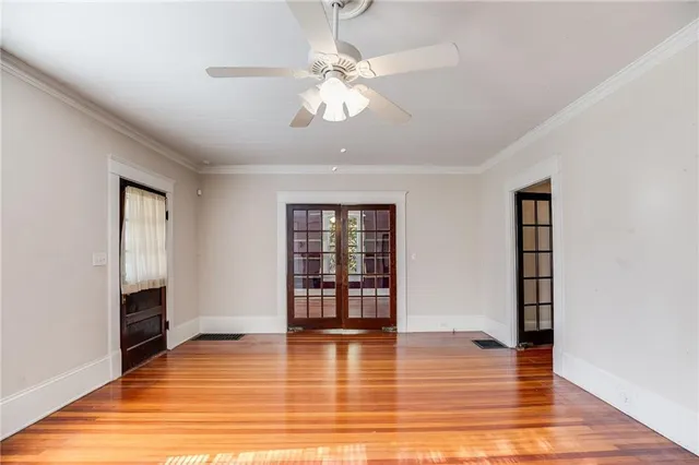 a view of an empty room with window and wooden floor