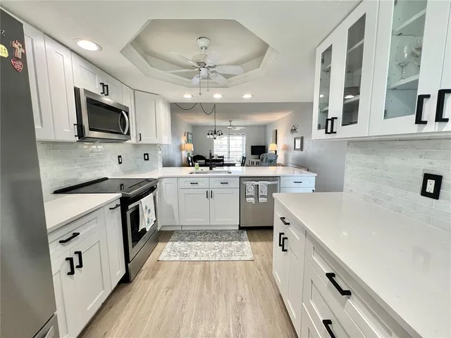 a kitchen with a sink a counter top space stainless steel appliances and a window