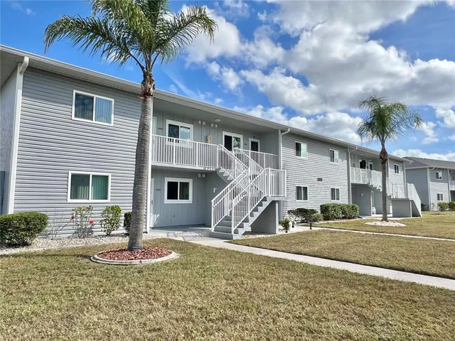 a front view of a house with garden and parking