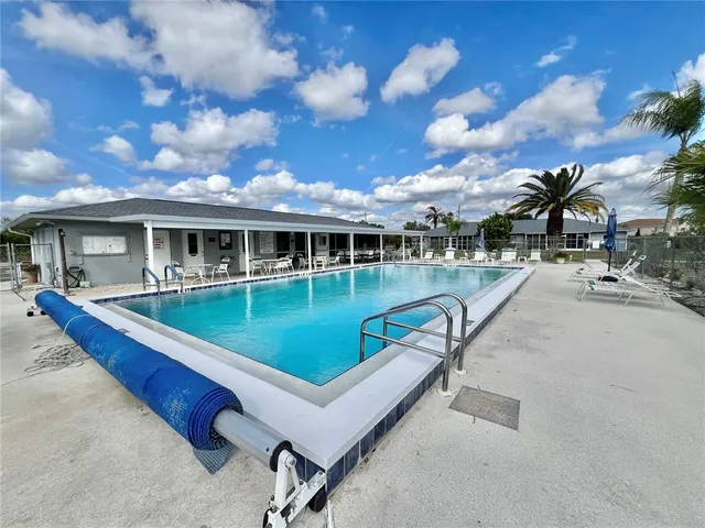 a view of a house with swimming pool and sitting area
